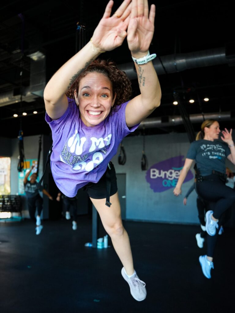 BungeeONE Studios member mid-jump in a bungee fitness class, photographed by TMC Marketing