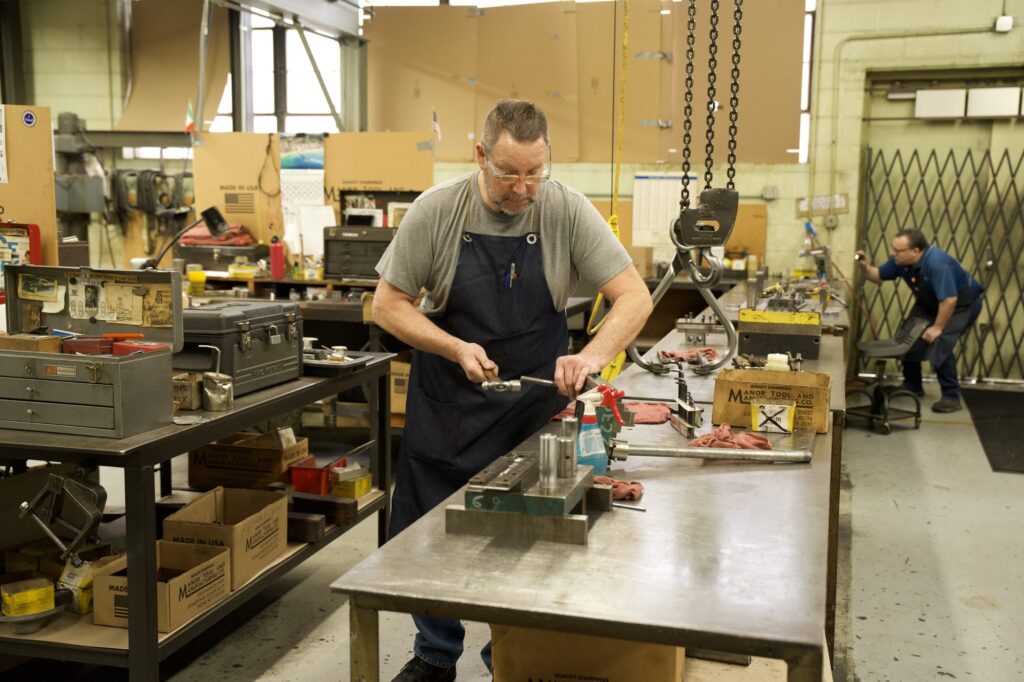 Machinist working at a bench on the shop floor at Manor Tool & Manufacturing, photographed by TMC Marketing