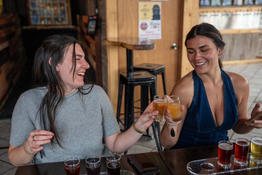 Two guests raising a toast at a local taproom