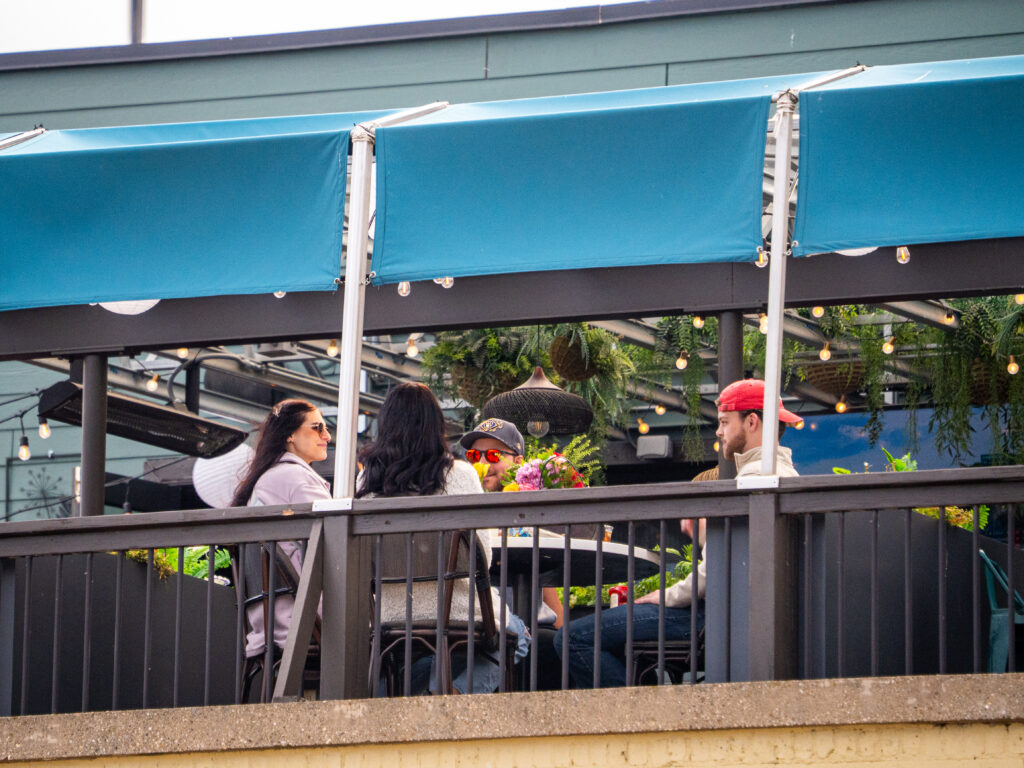 Friends dining on a covered patio in downtown Kenosha, photographed by TMC Marketing