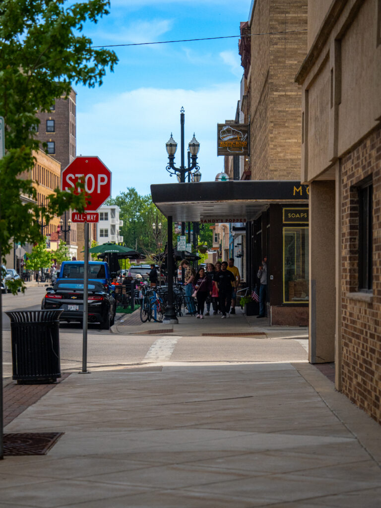 Downtown Kenosha sidewalk and storefronts on a sunny afternoon, photographed by TMC Marketing