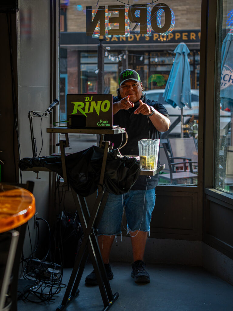 A DJ performing in a downtown Kenosha shop window, photographed by TMC Marketing